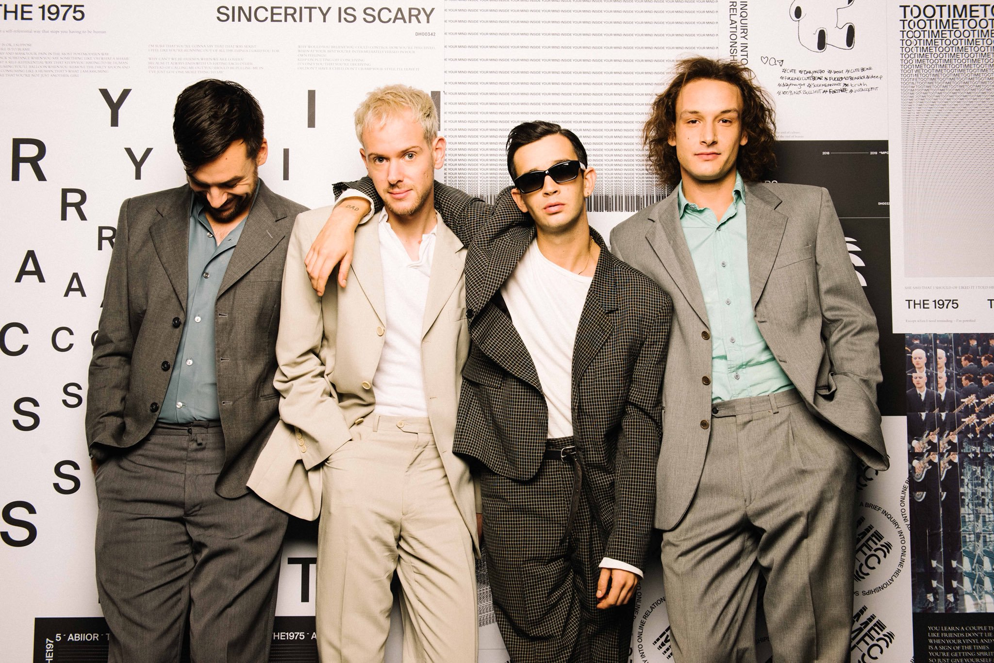 All four members of The 1975, standing side-by-side